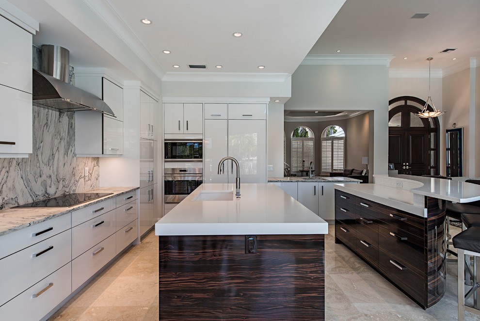 Contemporary kitchen in Minneapolis with a single-bowl sink, flat-panel cabinets, white cabinets, multi-coloured splashback, stone slab splashback, panelled appliances, multiple islands, beige floor and white benchtop.