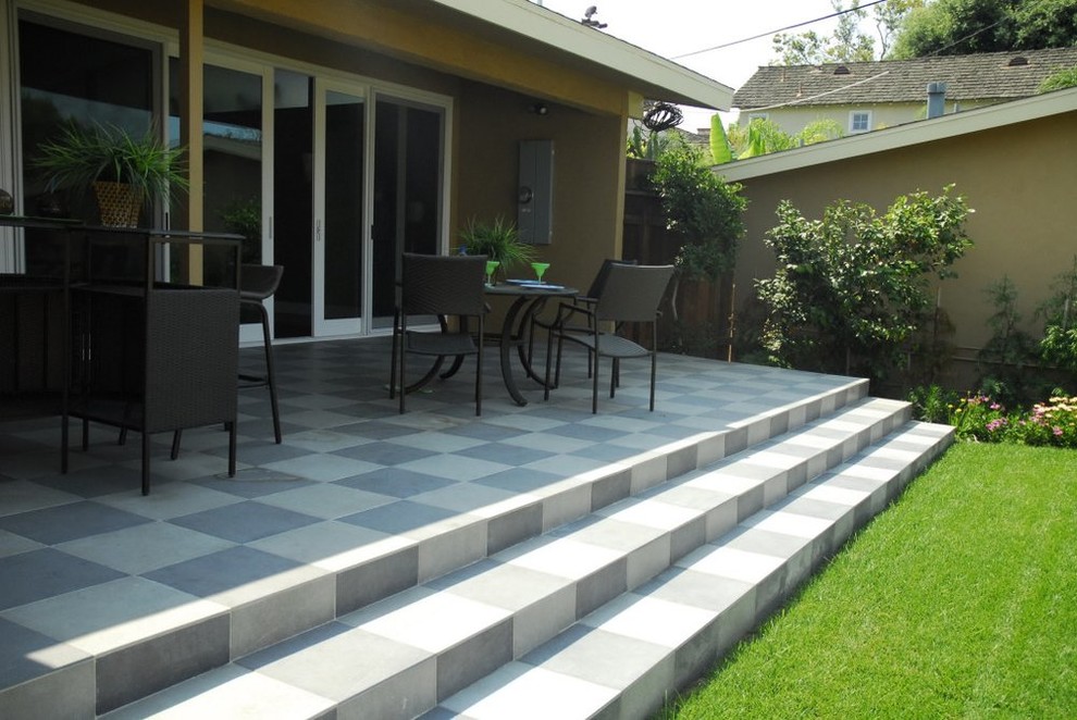 Design ideas for a large contemporary backyard patio in Orange County with a container garden, tile and a roof extension.