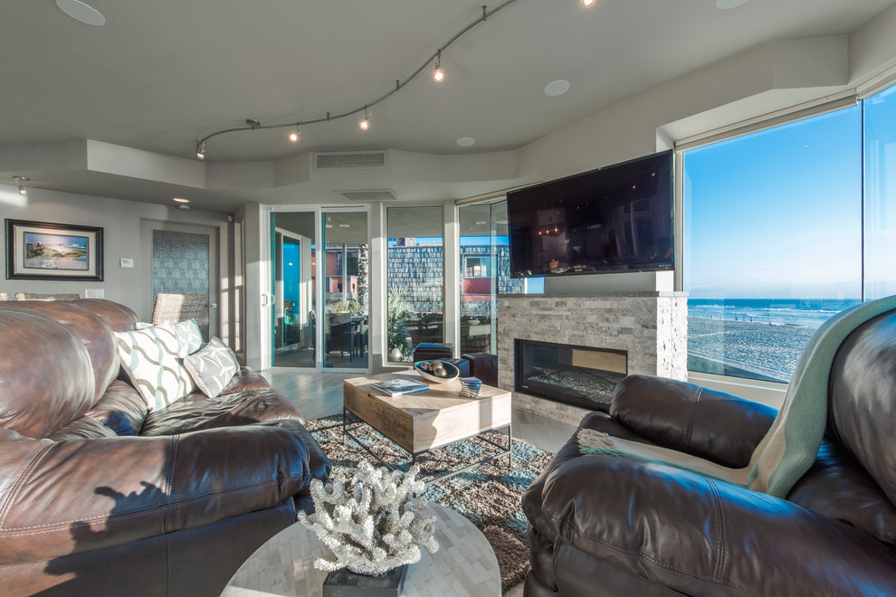 Inspiration for a mid-sized beach style open concept living room in San Diego with beige walls, light hardwood floors, a standard fireplace, a stone fireplace surround and a wall-mounted tv.