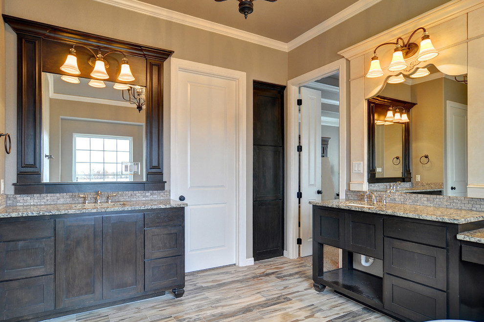 Inspiration for a large transitional master bathroom in Dallas with an undermount sink, flat-panel cabinets, black cabinets, granite benchtops, a freestanding tub, a corner shower, a two-piece toilet, brown tile, stone tile, beige walls and ceramic floors.
