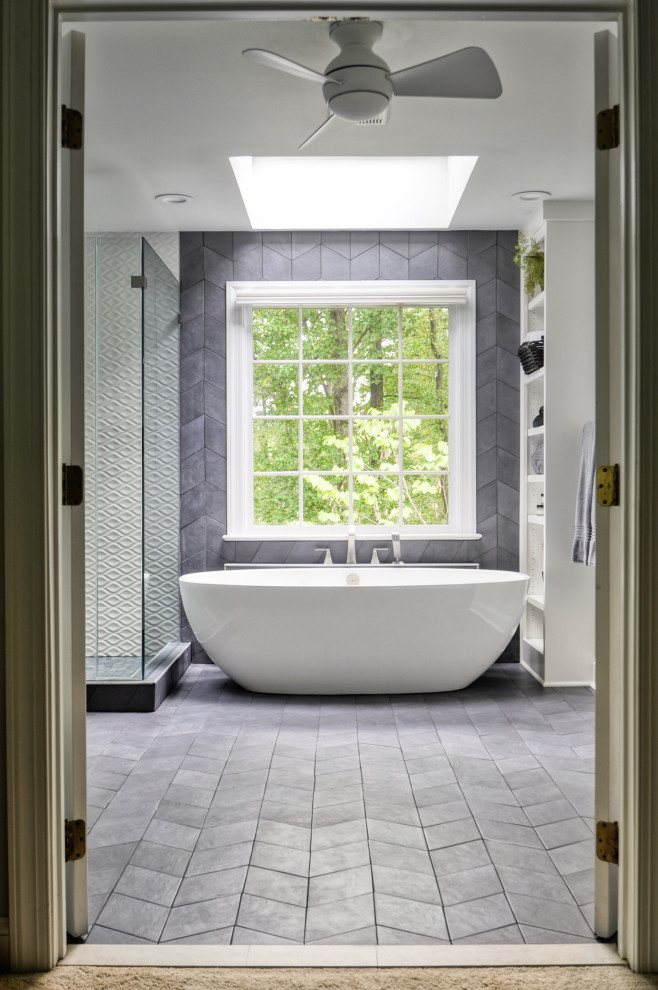 This is an example of a mid-sized modern master bathroom in DC Metro with recessed-panel cabinets, white cabinets, a freestanding tub, a corner shower, a two-piece toilet, white tile, ceramic tile, grey walls, cement tiles, an undermount sink, marble benchtops, grey floor, a hinged shower door and white benchtops.