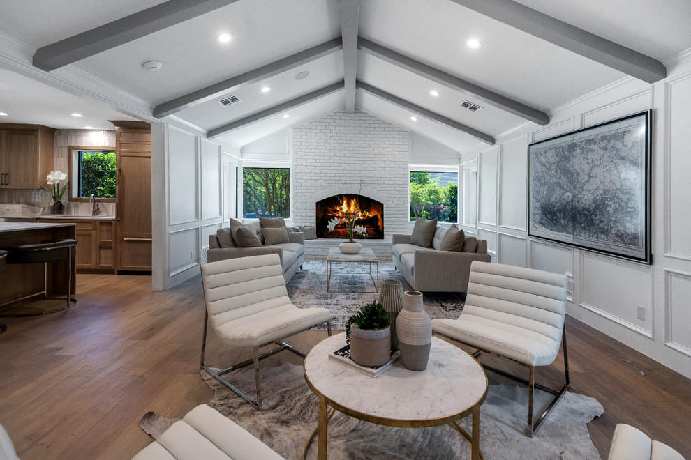 Large transitional open concept family room in Dallas with a home bar, white walls, light hardwood floors, a standard fireplace, a brick fireplace surround, a corner tv and beige floor.
