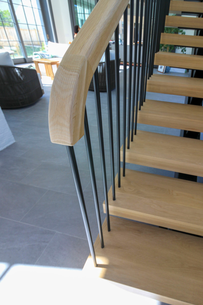 Esempio di un'ampia scala sospesa minimalista con pedata in legno, parapetto in materiali misti e pareti in perlinato