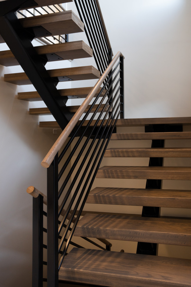 Идея дизайна: большая лестница на больцах в стиле неоклассика (современная классика) с металлическими перилами без подступенок