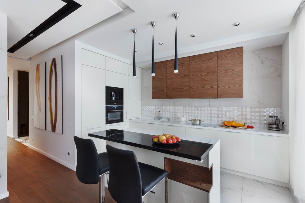 Inspiration for a mid-sized contemporary l-shaped open plan kitchen in Yekaterinburg with an undermount sink, flat-panel cabinets, white cabinets, solid surface benchtops, white splashback, porcelain splashback, white appliances, medium hardwood floors, with island, brown floor and white benchtop.