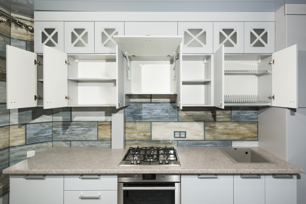 Стильный дизайн: параллельная кухня среднего размера в стиле неоклассика (современная классика) с обеденным столом, серыми фасадами и акцентной стеной без острова - последний тренд