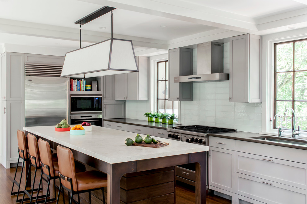 Design ideas for a transitional galley kitchen in Boston with an undermount sink, shaker cabinets, grey cabinets, glass tile splashback, stainless steel appliances, dark hardwood floors and with island.