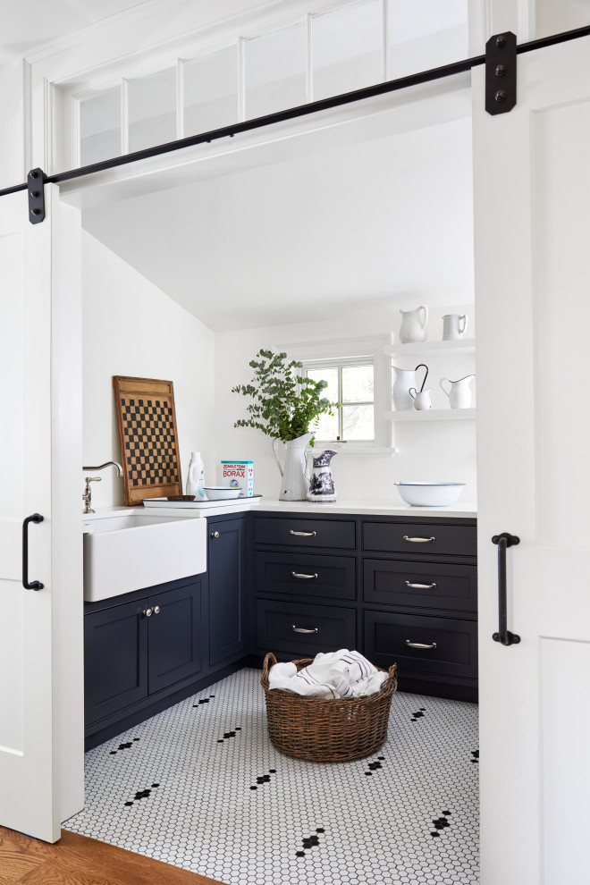 Mid-sized country u-shaped dedicated laundry room in Boston with a farmhouse sink, beaded inset cabinets, black cabinets, quartz benchtops, white walls, ceramic floors, a side-by-side washer and dryer, white floor and white benchtop.