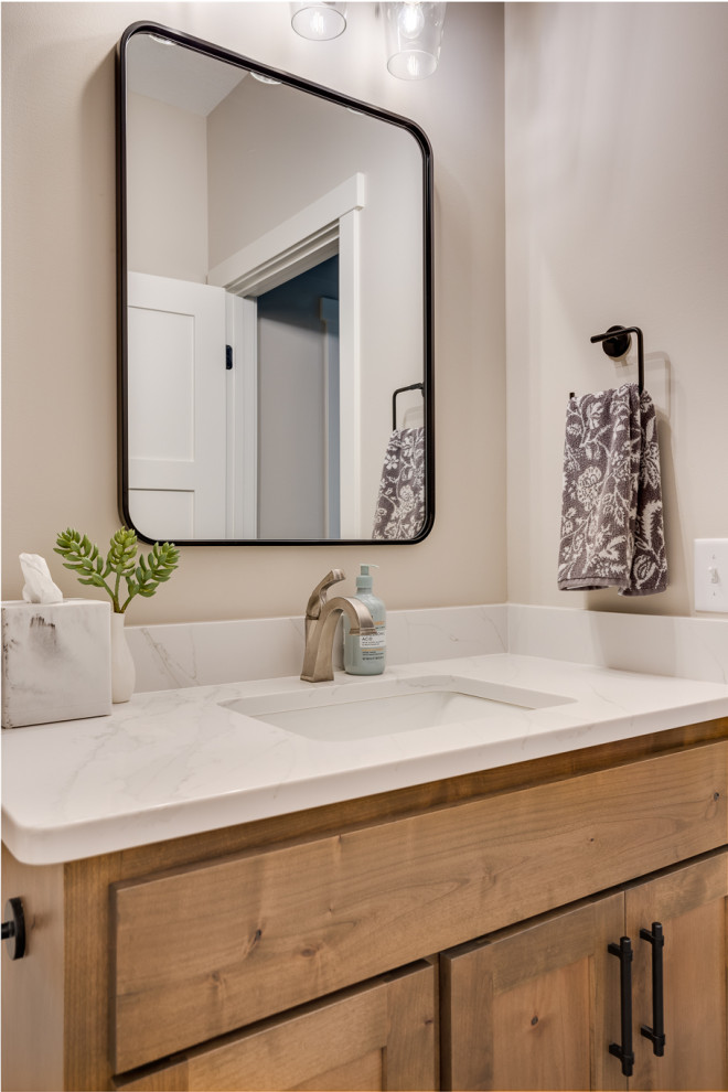 This is an example of a large arts and crafts powder room in Other with shaker cabinets, green cabinets, a one-piece toilet, white tile, porcelain tile, beige walls, porcelain floors, an undermount sink, engineered quartz benchtops, beige floor, white benchtops and a built-in vanity.