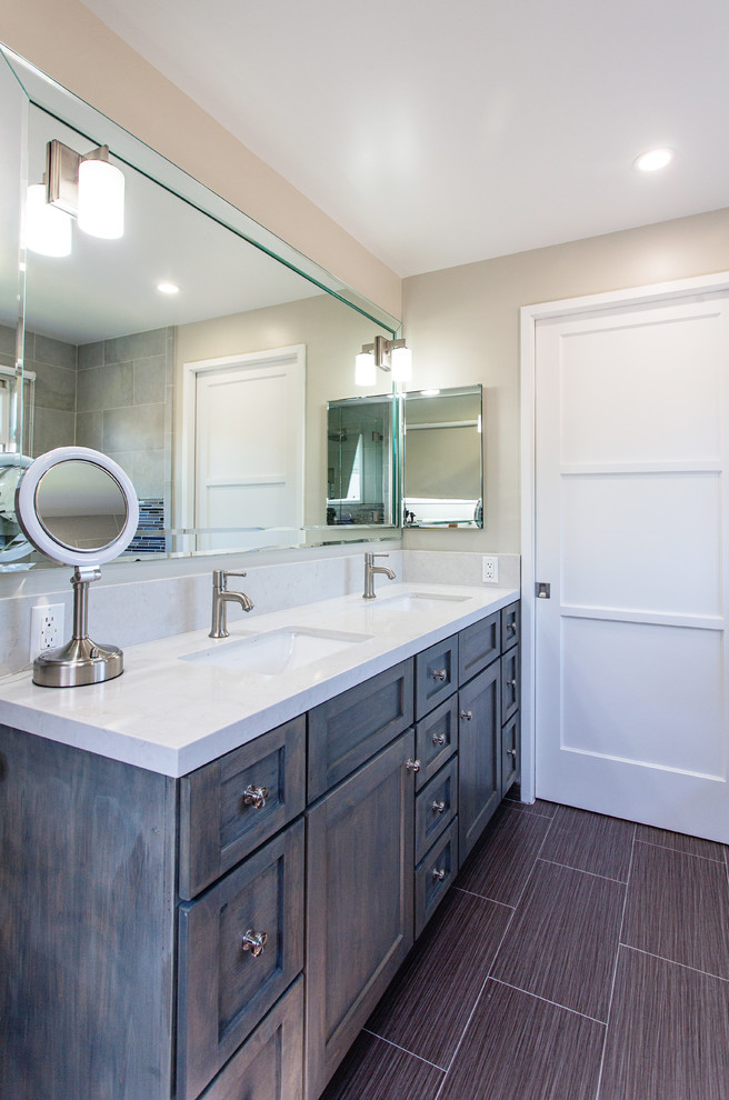 Inspiration for a mid-sized transitional master bathroom in Los Angeles with an undermount sink, shaker cabinets, engineered quartz benchtops, porcelain floors, grey cabinets, a drop-in tub, gray tile, porcelain tile and beige walls.