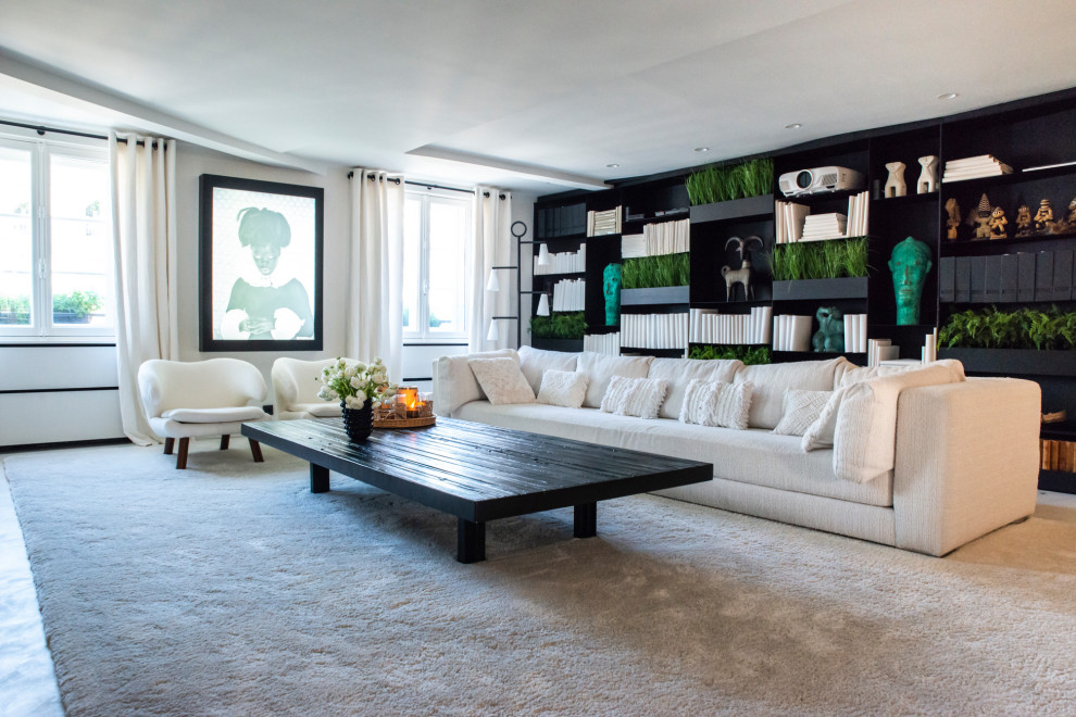 This is an example of a large contemporary family room in Paris with a library, white walls and a concealed tv.