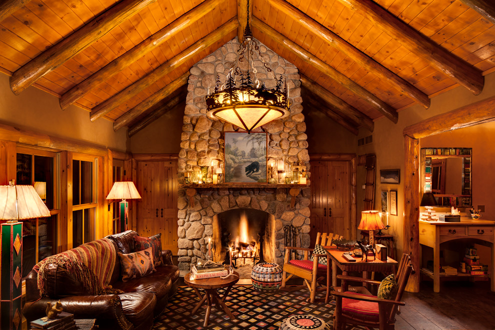 Inspiration for a large country living room in Milwaukee with a standard fireplace, a stone fireplace surround, dark hardwood floors and brown floor.