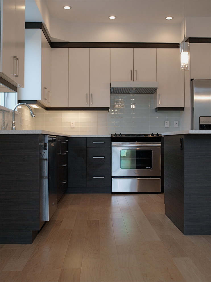 Design ideas for a contemporary l-shaped eat-in kitchen in Vancouver with an undermount sink, flat-panel cabinets, white cabinets, quartz benchtops, white splashback, glass tile splashback and stainless steel appliances.