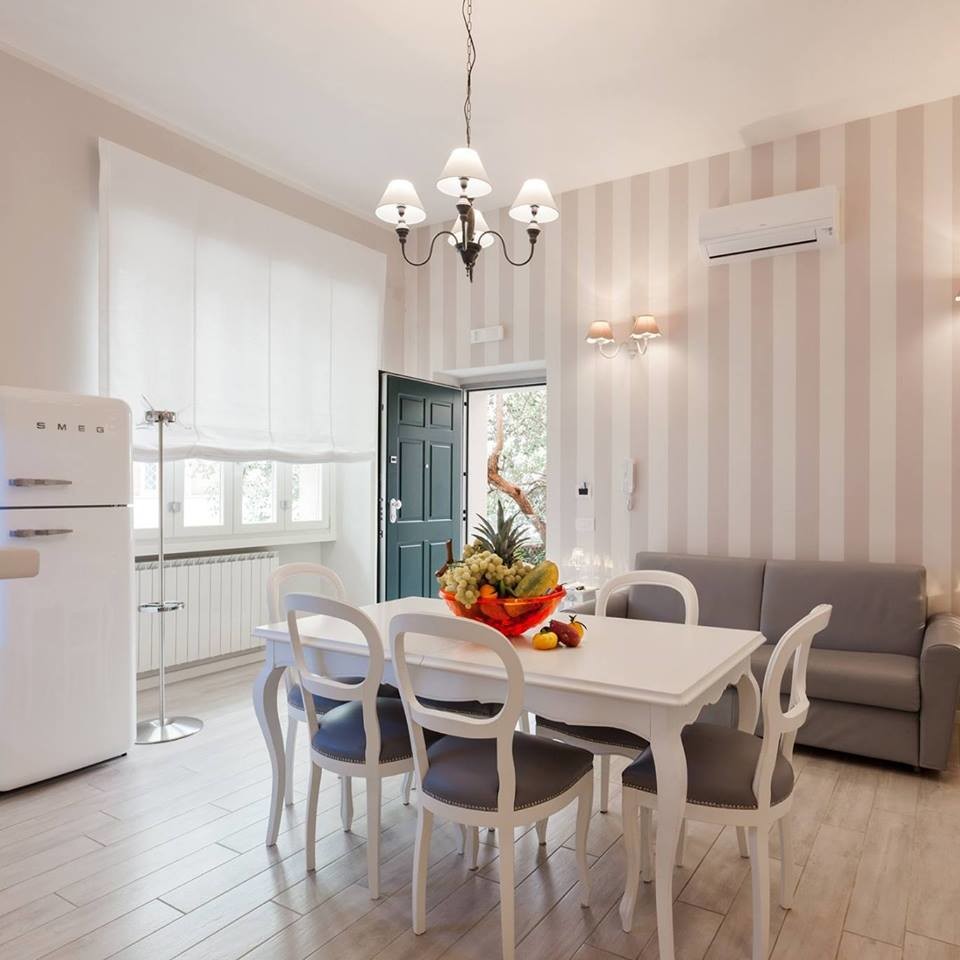 This is an example of a small traditional kitchen/dining combo in Rome with grey walls, porcelain floors and white floor.