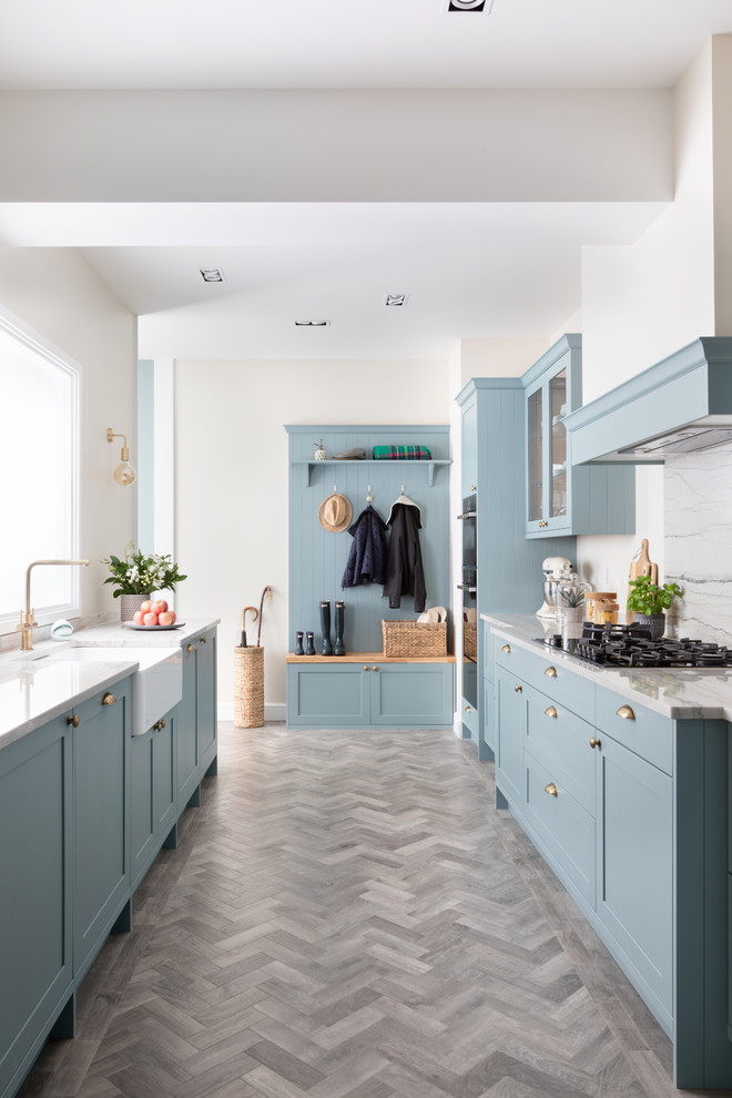 Inspiration for a mid-sized country galley kitchen in West Midlands with granite benchtops, white splashback, white benchtop, a farmhouse sink, shaker cabinets, blue cabinets, no island and grey floor.