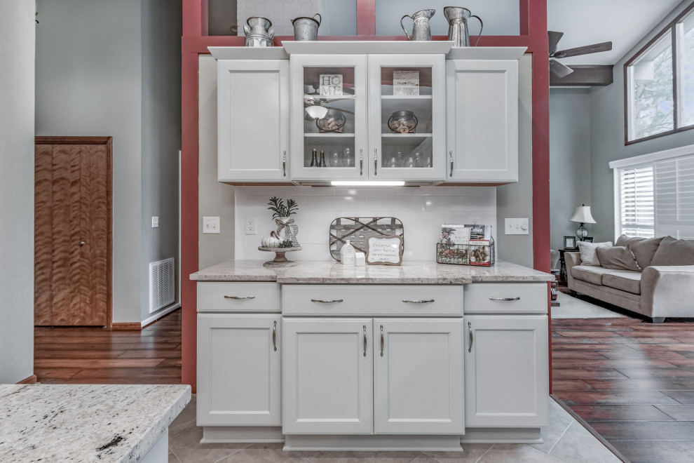 Inspiration for a mid-sized country u-shaped kitchen in Raleigh with a farmhouse sink, shaker cabinets, grey cabinets, granite benchtops, white splashback, subway tile splashback, stainless steel appliances and with island.