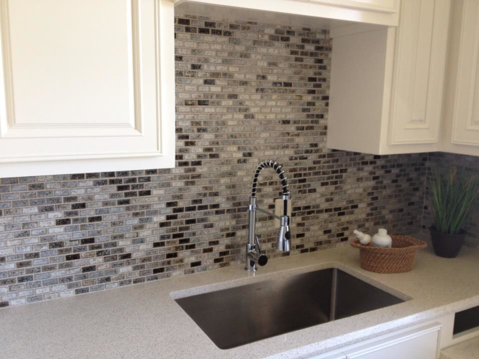Example of a mid-sized transitional u-shaped dark wood floor and multicolored floor eat-in kitchen design in Austin with a double-bowl sink, raised-panel cabinets, white cabinets, laminate countertops, multicolored backsplash, mosaic tile backsplash, stainless steel appliances and an island
