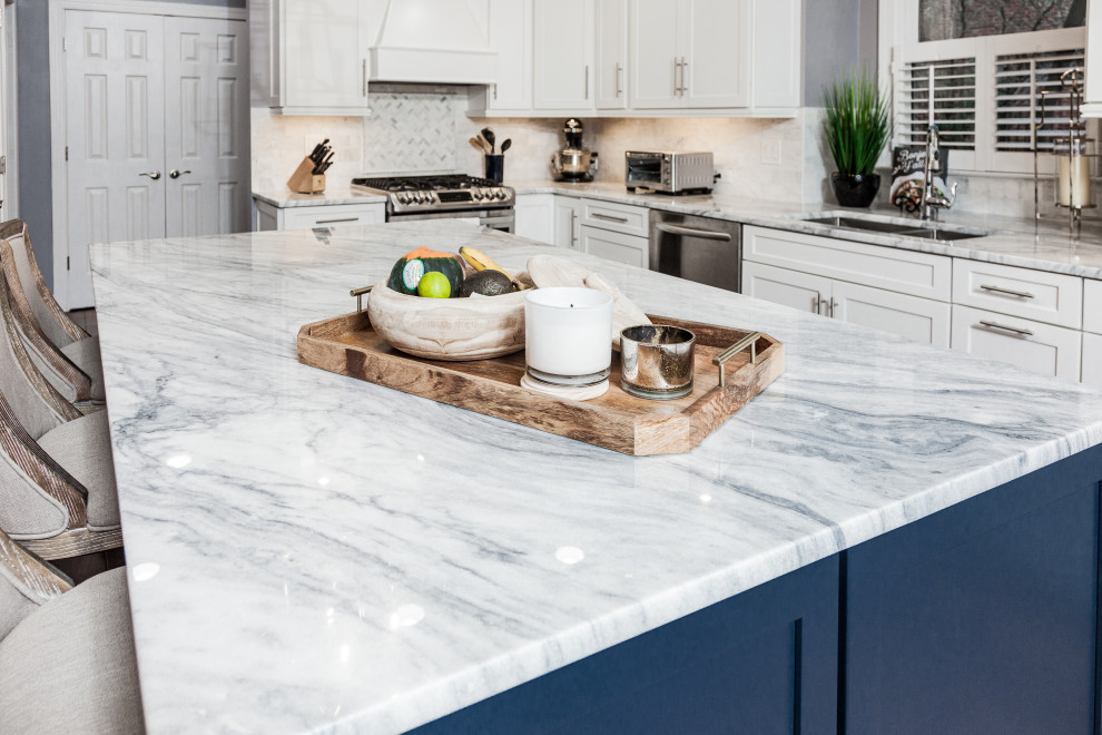 Design ideas for an expansive traditional eat-in kitchen in Atlanta with a double-bowl sink, shaker cabinets, blue cabinets, quartzite benchtops, white splashback, marble splashback, stainless steel appliances, medium hardwood floors, with island and white benchtop.