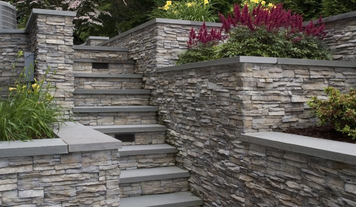 Inspiration for a mid-sized transitional side yard partial sun garden in St Louis with a retaining wall and natural stone pavers.