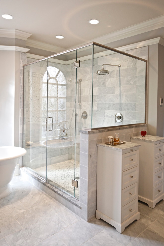 This is an example of a large traditional master bathroom in Columbus with an undermount sink, raised-panel cabinets, white cabinets, granite benchtops, a freestanding tub, a double shower, gray tile, stone tile, grey walls and marble floors.
