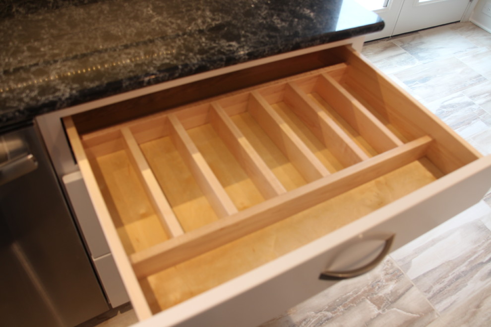 Inspiration for a mid-sized transitional u-shaped porcelain tile and beige floor eat-in kitchen remodel in DC Metro with an undermount sink, flat-panel cabinets, white cabinets, quartz countertops, white backsplash, ceramic backsplash, stainless steel appliances, an island and black countertops