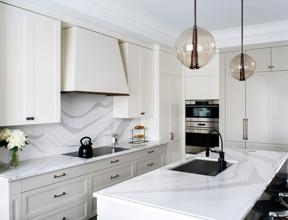 This is an example of a large contemporary kitchen in Other with an undermount sink, recessed-panel cabinets, white cabinets, marble benchtops, white splashback, stone slab splashback, stainless steel appliances and with island.
