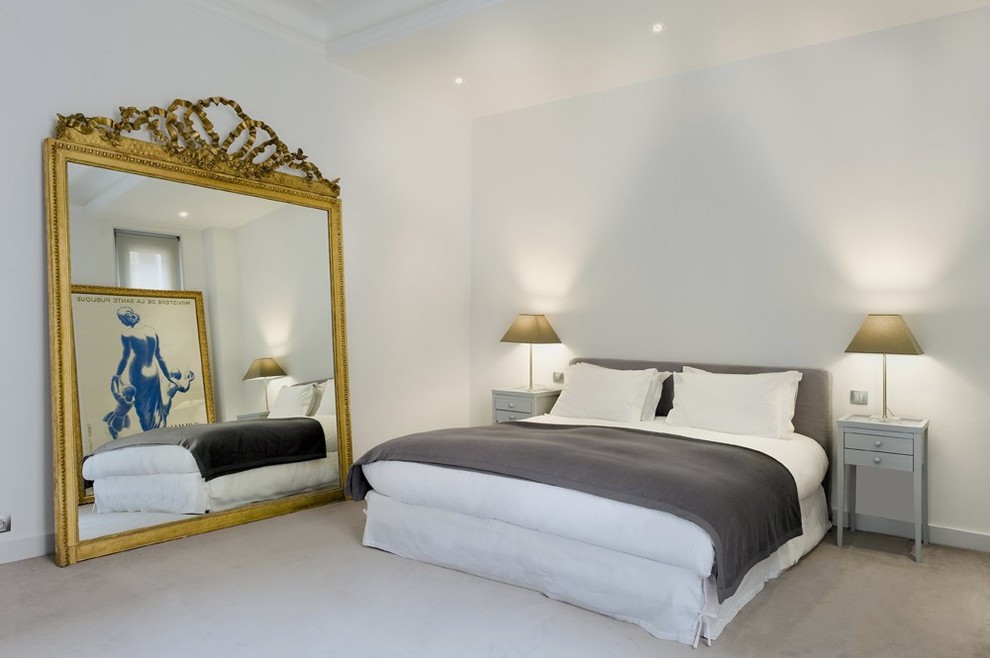 This is an example of a mid-sized contemporary master bedroom in Paris with white walls and carpet.