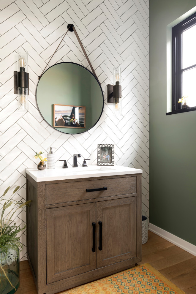 Powder room - mid-sized coastal white tile light wood floor powder room idea in Minneapolis with medium tone wood cabinets, gray walls, white countertops and a freestanding vanity