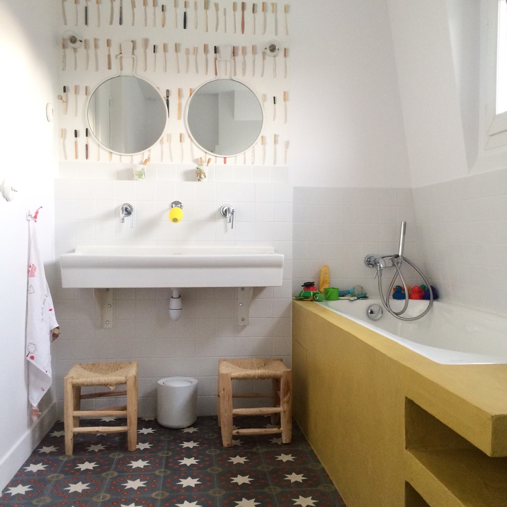 Design ideas for a mid-sized contemporary kids bathroom in Paris with a drop-in tub, white walls, ceramic floors, a wall-mount sink and white tile.