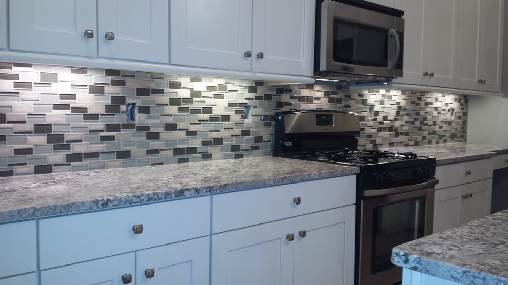 Inspiration for a small transitional galley open concept kitchen remodel in St Louis with shaker cabinets, white cabinets, granite countertops, multicolored backsplash, mosaic tile backsplash, stainless steel appliances and a peninsula