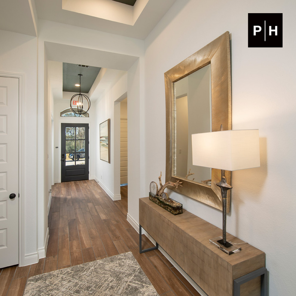 Eingang mit Korridor, weißer Wandfarbe, braunem Holzboden, Einzeltür, dunkler Holzhaustür und eingelassener Decke in Houston