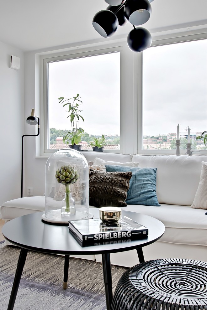 Design ideas for a scandinavian formal open concept living room in Gothenburg with white walls, light hardwood floors and no tv.