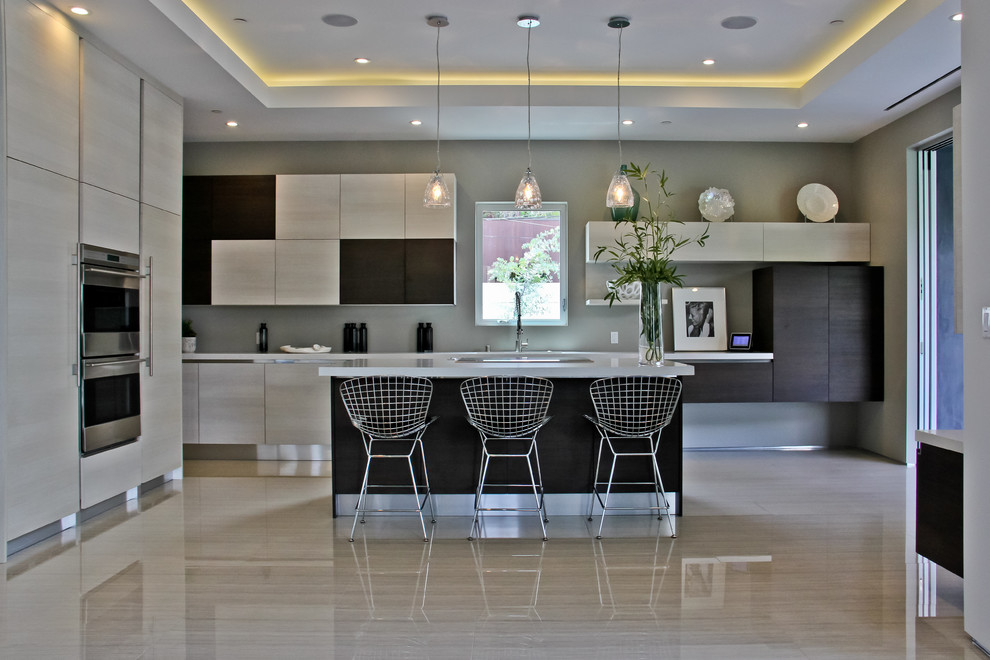 This is an example of a large contemporary l-shaped eat-in kitchen in Los Angeles with flat-panel cabinets, light wood cabinets, stainless steel appliances, an undermount sink, porcelain floors and with island.