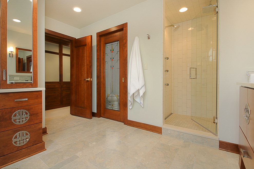 Design ideas for a large asian master bathroom in Chicago with flat-panel cabinets, medium wood cabinets, a freestanding tub, an alcove shower, blue tile, glass tile, white walls, marble floors, an undermount sink and solid surface benchtops.