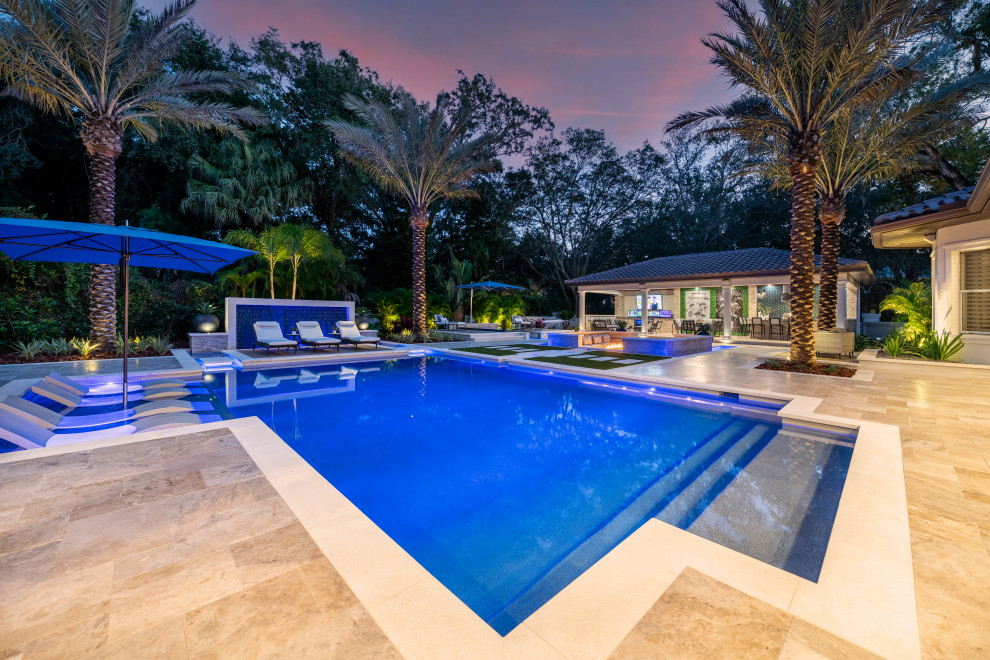 Ejemplo de casa de la piscina y piscina infinita actual extra grande a medida en patio trasero con suelo de baldosas