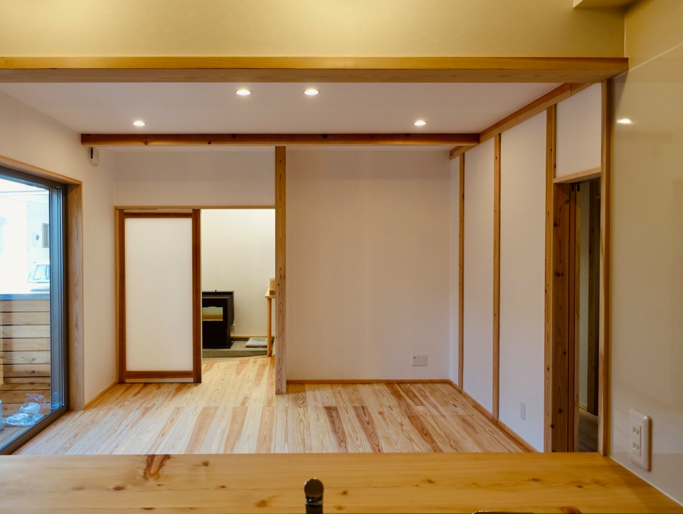 Idées déco pour une salle de séjour avec un sol en bois brun, un poêle à bois, un sol beige, un plafond en papier peint et du papier peint.
