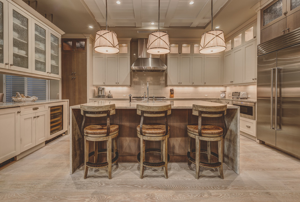 Country kitchen in Other with an undermount sink, shaker cabinets, light wood cabinets, marble benchtops, stainless steel appliances, light hardwood floors and with island.