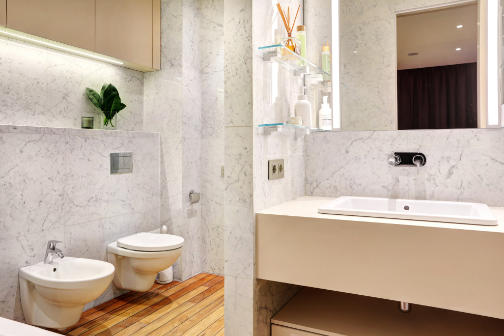 Photo of a contemporary bathroom in Saint Petersburg with flat-panel cabinets, beige cabinets, a drop-in tub, an alcove shower, a wall-mount toilet, black and white tile, porcelain tile, white walls, a drop-in sink, engineered quartz benchtops, a hinged shower door, beige benchtops, a single vanity and a floating vanity.