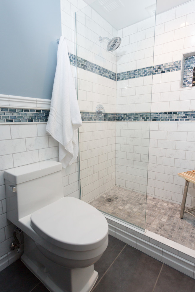 Photo of a small transitional 3/4 bathroom in Chicago with glass-front cabinets, dark wood cabinets, a one-piece toilet, white tile, subway tile, blue walls, ceramic floors, a vessel sink, engineered quartz benchtops, an alcove shower and a hinged shower door.