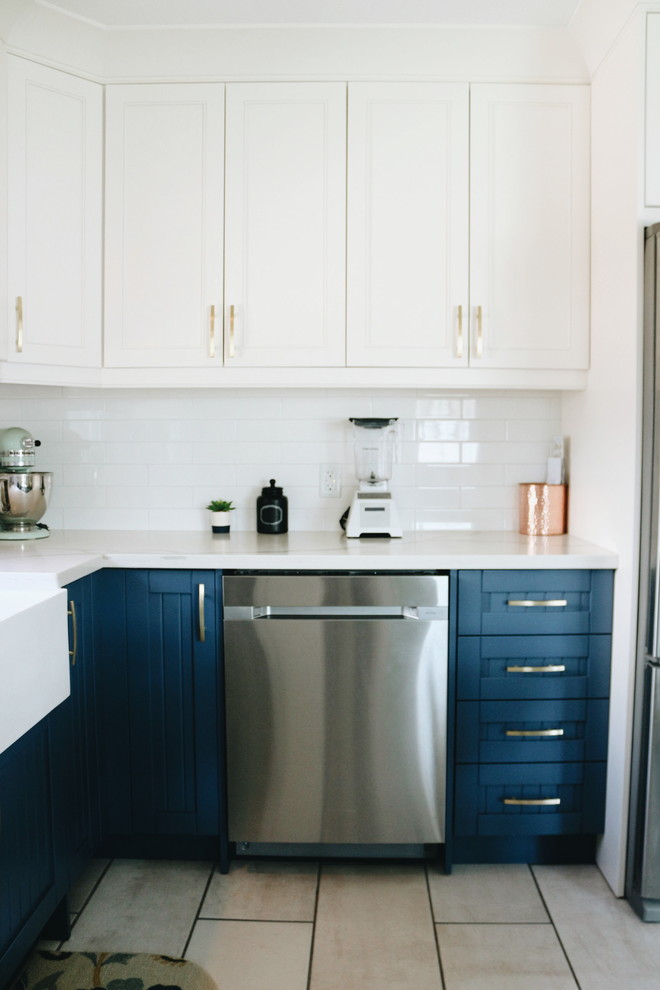 Inspiration for a mid-sized transitional u-shaped porcelain tile and multicolored floor eat-in kitchen remodel in Toronto with a farmhouse sink, beaded inset cabinets, blue cabinets, quartzite countertops, white backsplash, ceramic backsplash, stainless steel appliances, no island and multicolored countertops