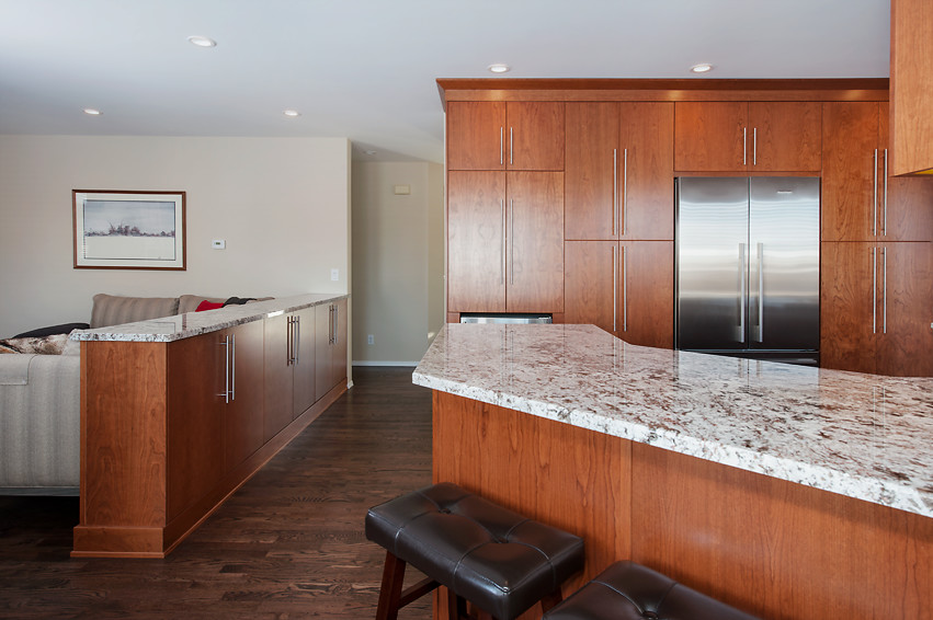 Example of a mid-sized transitional u-shaped dark wood floor open concept kitchen design in Calgary with an undermount sink, flat-panel cabinets, medium tone wood cabinets, granite countertops, white backsplash, mirror backsplash, stainless steel appliances and an island