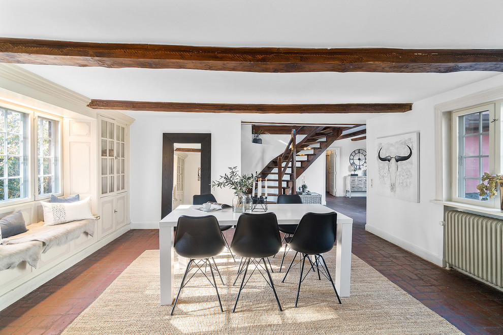 Design ideas for a mid-sized country separate dining room in Copenhagen with white walls, brick floors and brown floor.