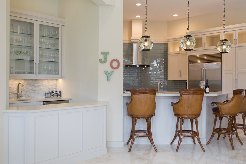 Large transitional u-shaped porcelain tile and beige floor enclosed kitchen photo in Miami with an undermount sink, beaded inset cabinets, white cabinets, quartzite countertops, blue backsplash, subway tile backsplash, stainless steel appliances and an island