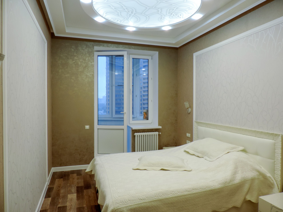 Modelo de dormitorio principal tradicional renovado de tamaño medio sin chimenea con paredes multicolor, suelo laminado, suelo rojo, bandeja y papel pintado
