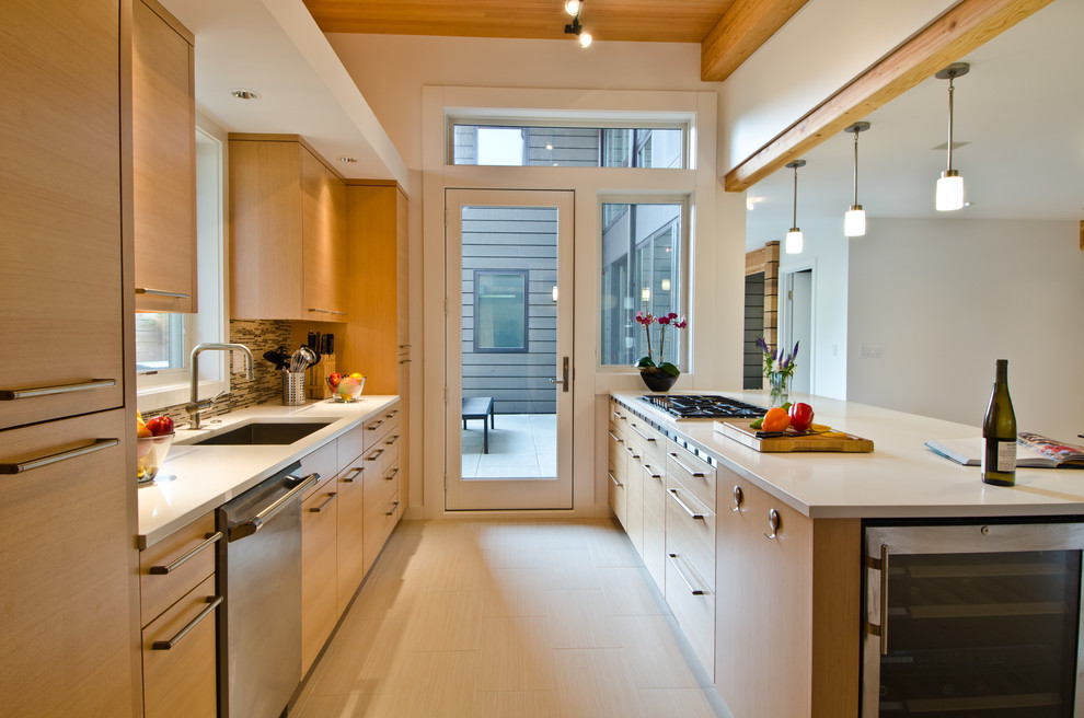 Photo of a contemporary galley eat-in kitchen in Seattle with an undermount sink, flat-panel cabinets, light wood cabinets, multi-coloured splashback, matchstick tile splashback, stainless steel appliances, solid surface benchtops, light hardwood floors and no island.