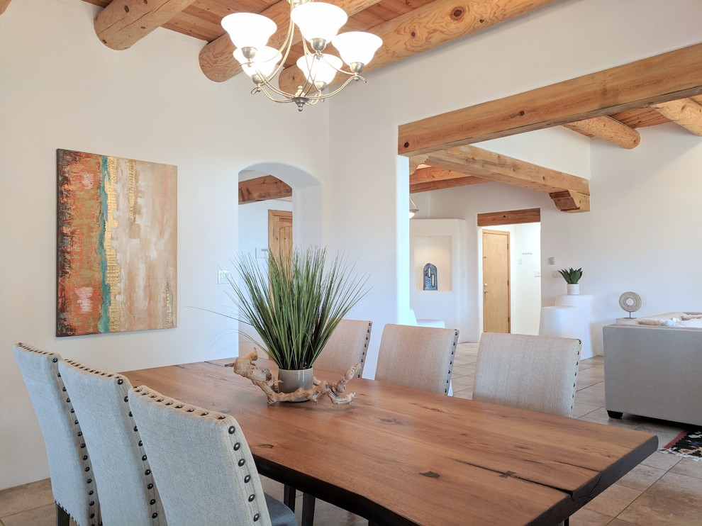 Inspiration for a mid-sized kitchen/dining combo in Other with white walls, travertine floors, a corner fireplace, a plaster fireplace surround and beige floor.