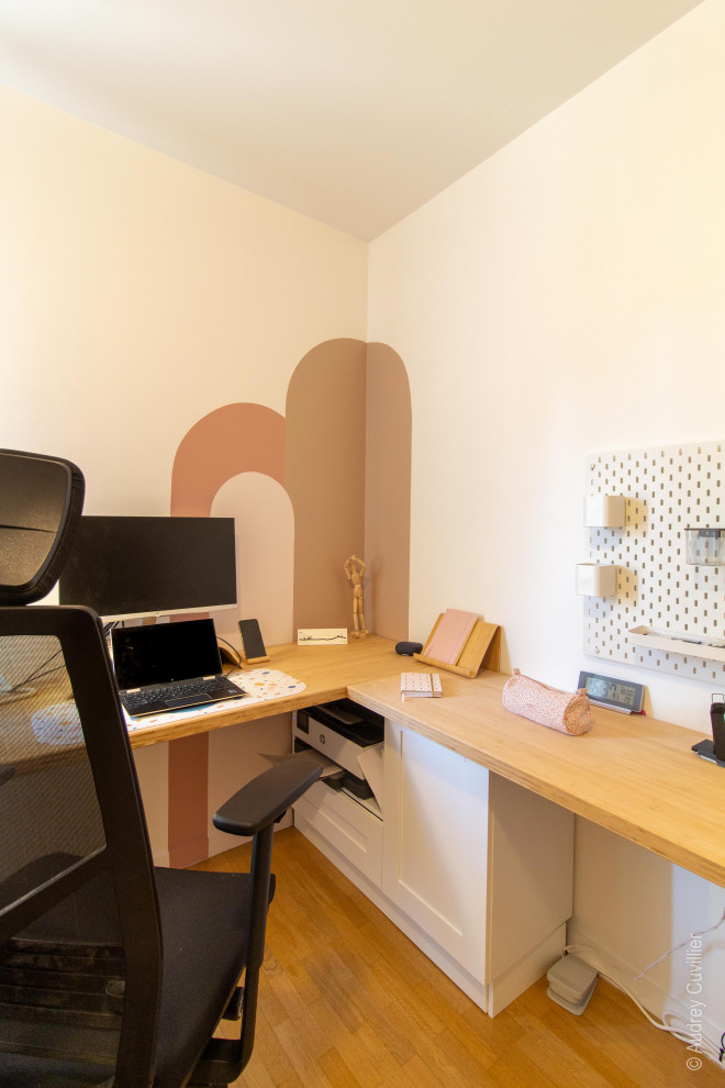 Immagine di un grande ufficio scandinavo con pareti rosa, parquet scuro e scrivania autoportante