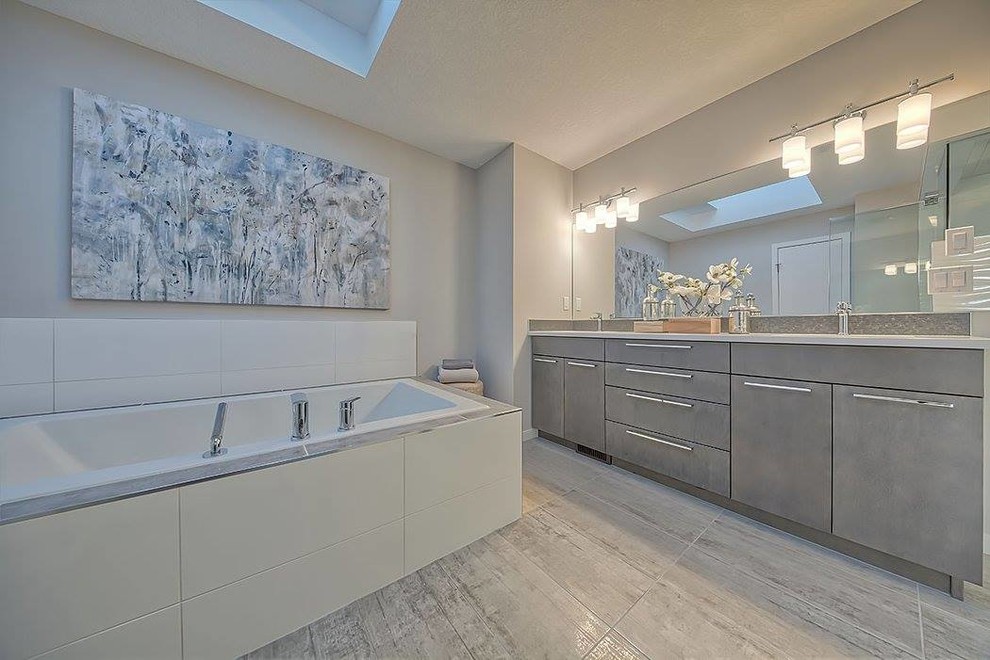 Photo of a large contemporary master bathroom in Calgary with flat-panel cabinets, grey cabinets, a drop-in tub, a corner shower, grey walls, plywood floors, an undermount sink and engineered quartz benchtops.