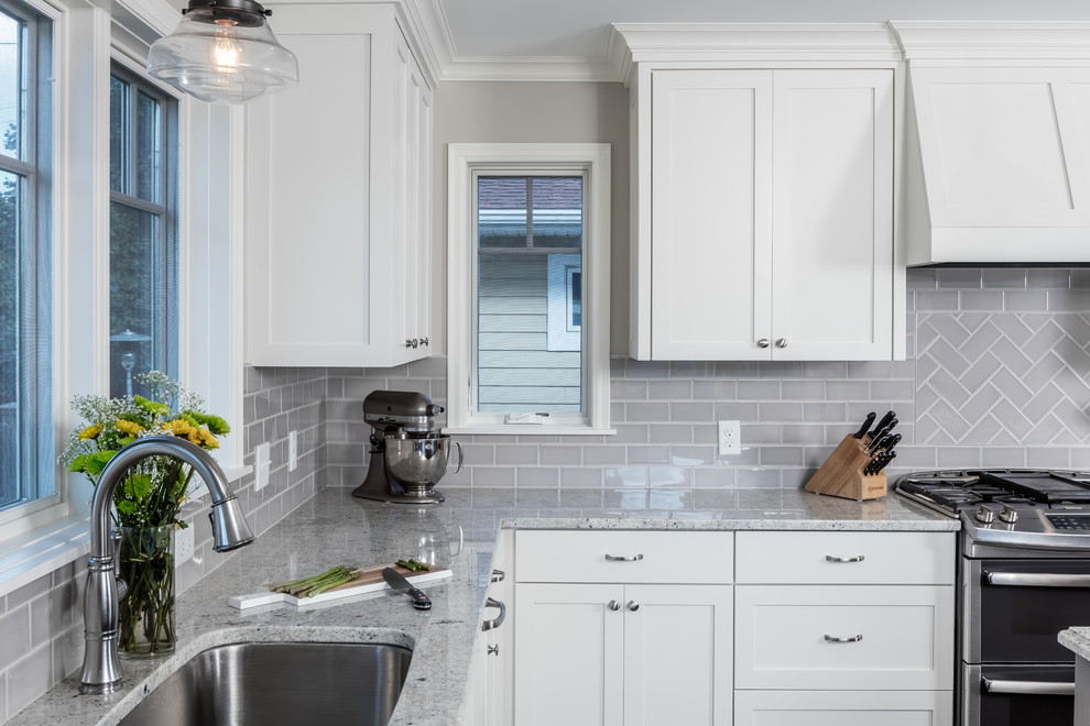 Inspiration for a mid-sized traditional l-shaped eat-in kitchen in Minneapolis with an undermount sink, shaker cabinets, white cabinets, granite benchtops, grey splashback, subway tile splashback, stainless steel appliances, dark hardwood floors and with island.