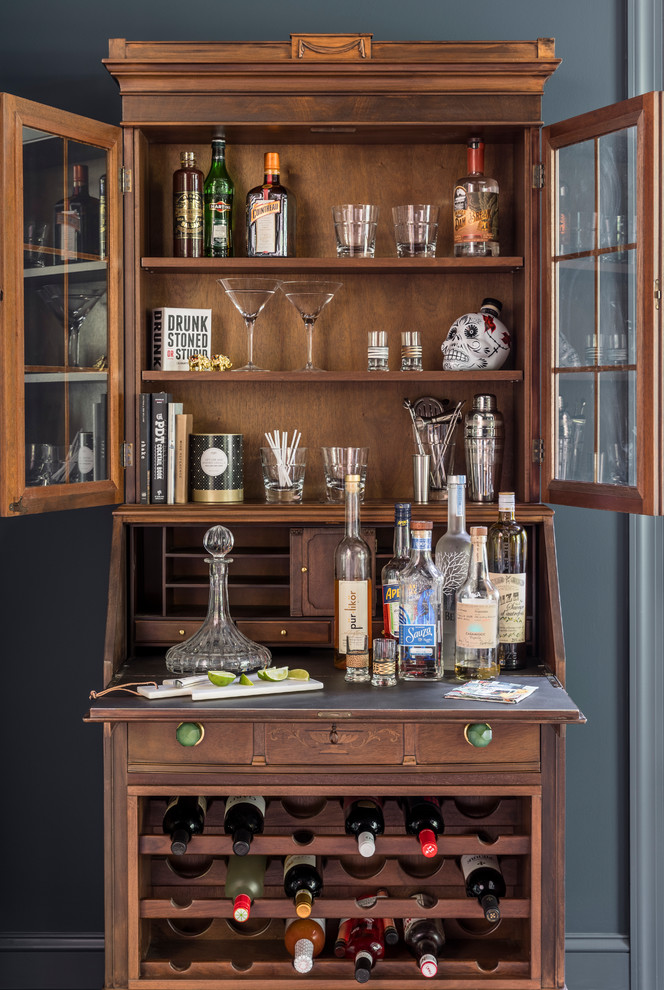 This is an example of an eclectic bar cart in New York with dark wood cabinets.